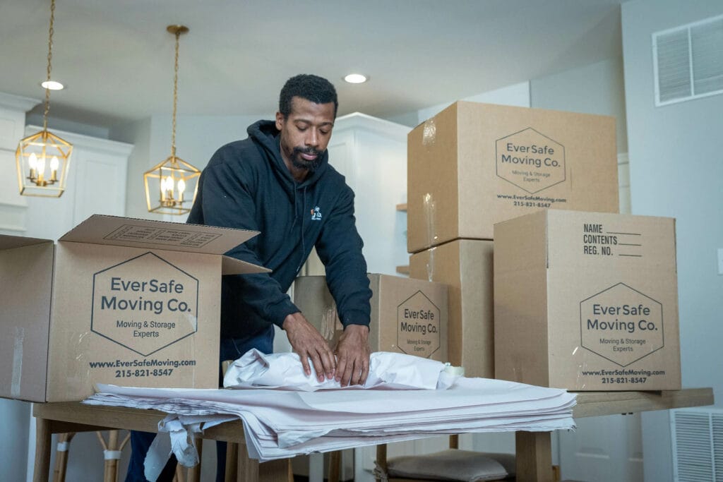 An Eversafe mover carefully packs items into a box as part of their packaging service.