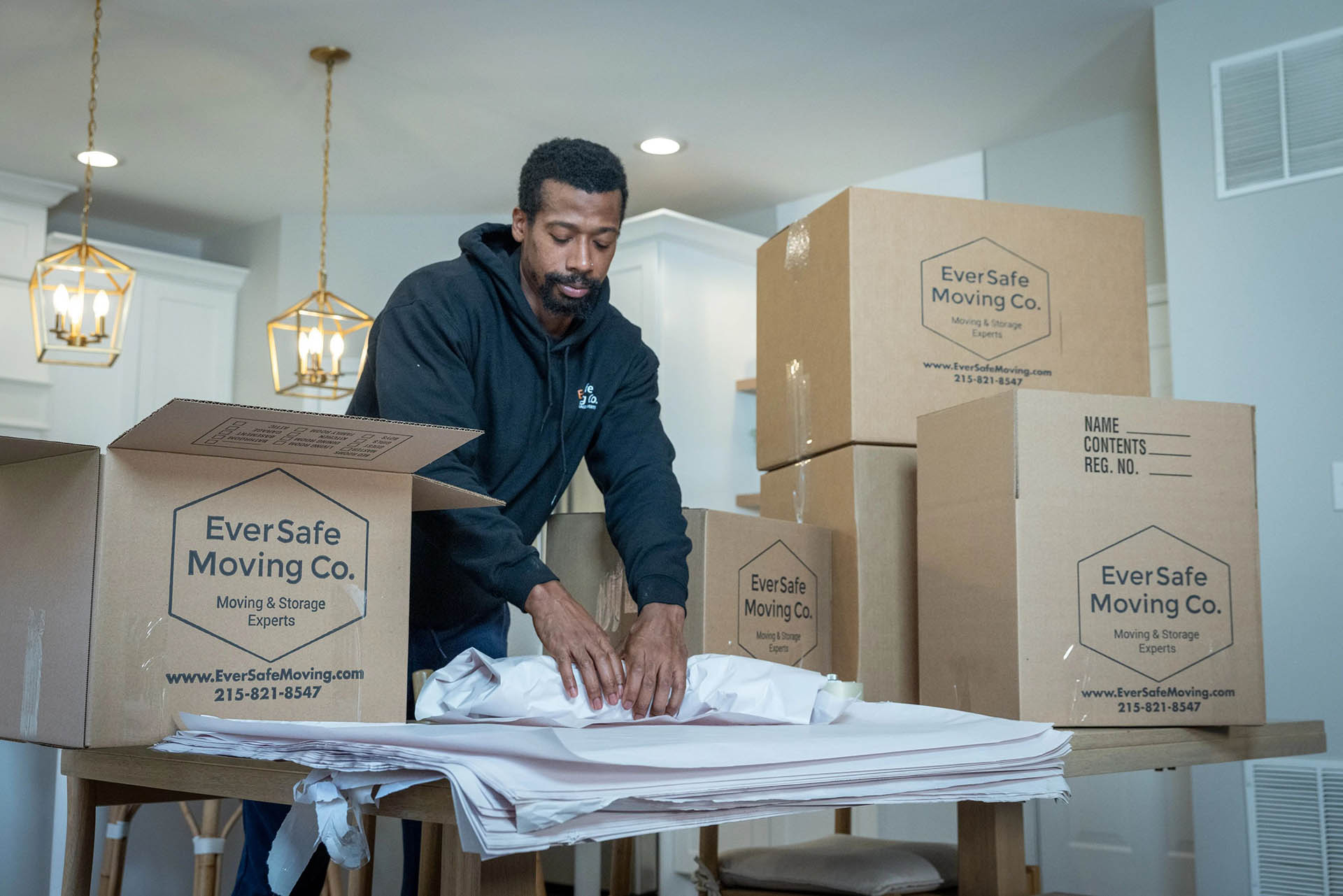 An Eversafe mover carefully packs items into a box as part of their packaging service.