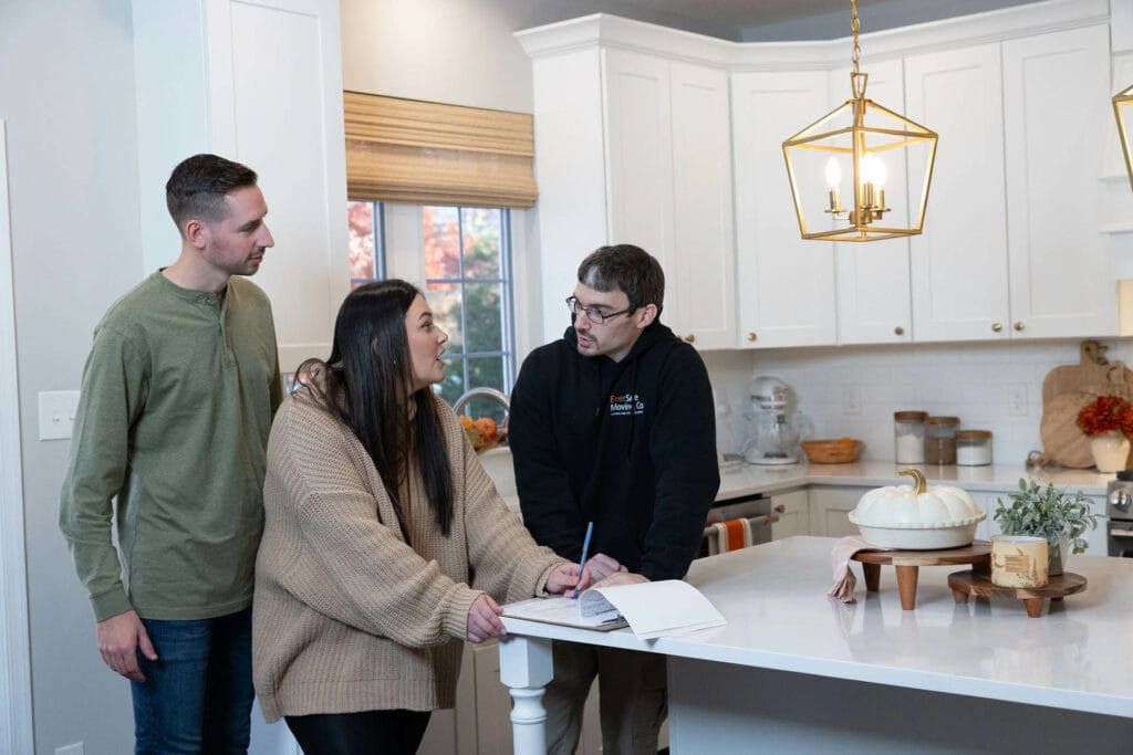 An EverSafe mover reviews paperwork with a couple inside a bright kitchen