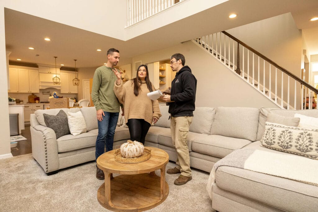 A woman gestures while speaking with a mover, discussing logistics in a spacious home