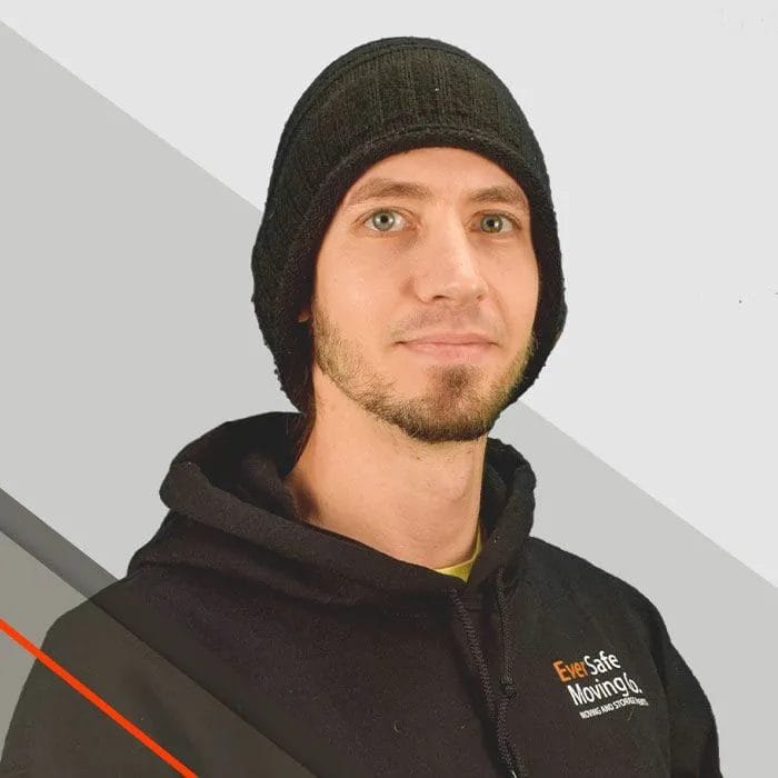Fred, Mover, wearing a beanie poses in branded gear against a clean background