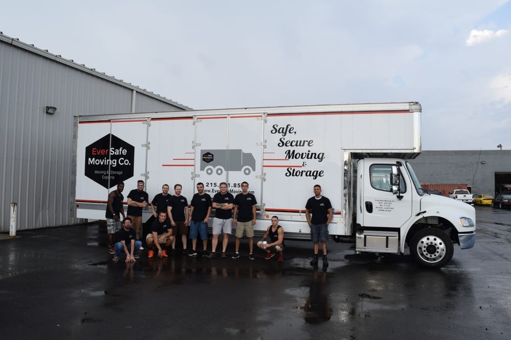 Eversafe Moving Co. team poses in front of their branded moving truck in a parking lot