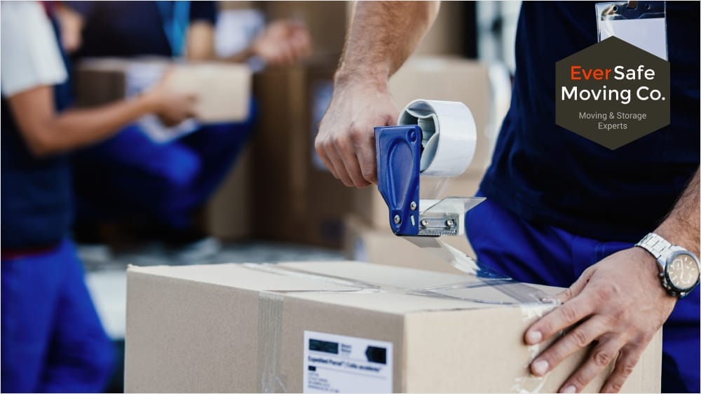 Professional mover taping a cardboard box as part of packing and moving services